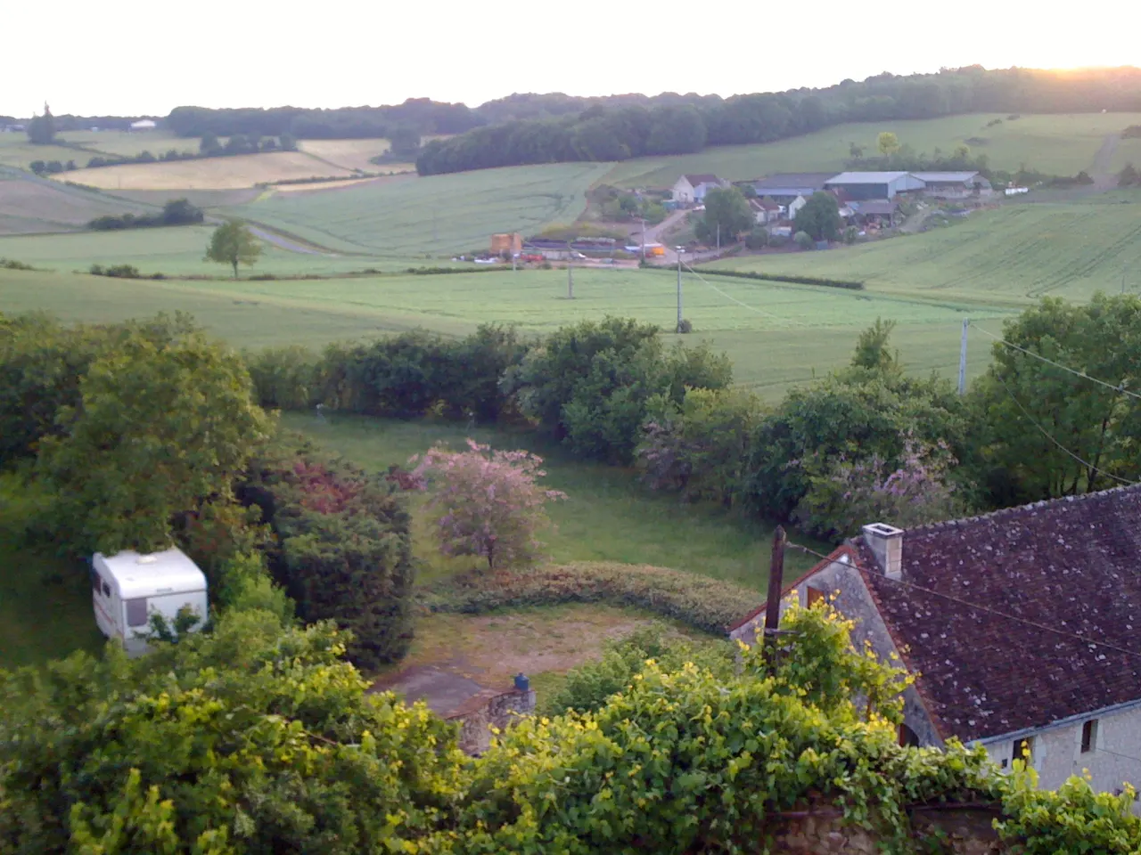 La campagne vallonnée de Lésigny vue depuis le château d’Alogny : prés, haies et fermes au soleil couchant