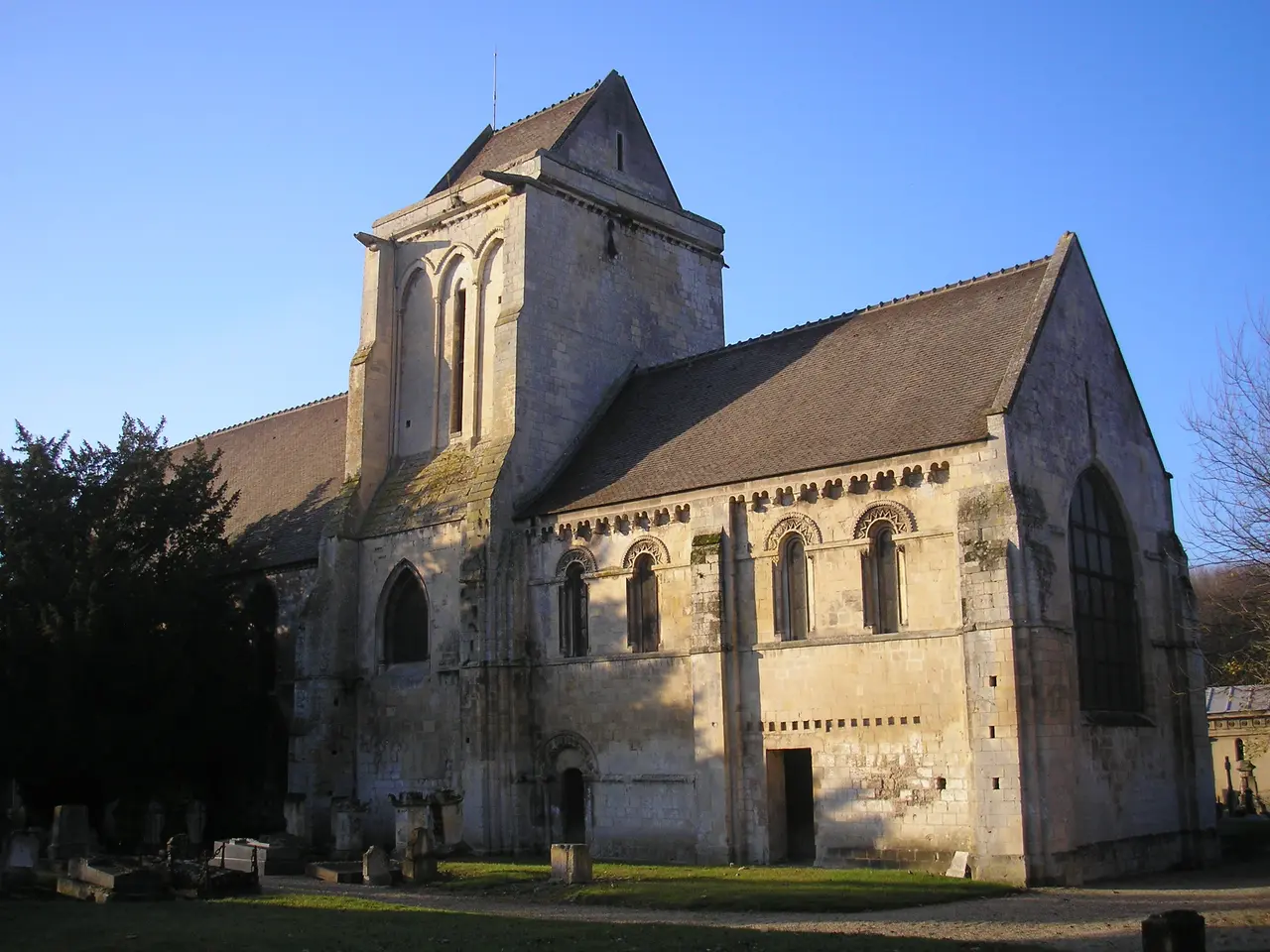 L’église Notre-Dame-des-Prés de Mondeville, son clocher massif et sa nef aux fenêtres en plein cintre, dans la lumière rasante
