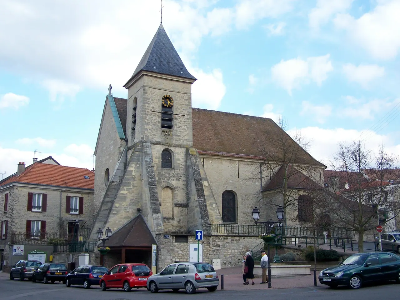 L’église Notre-Dame de Montesson et son clocher de pierre à flèche d’ardoise, au bord d’une place du centre