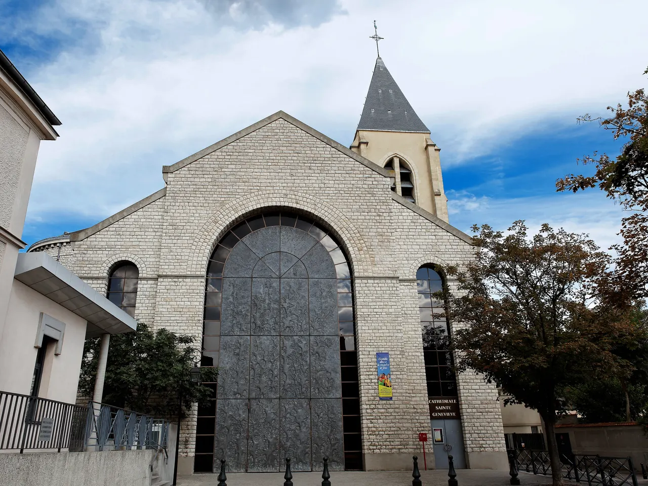 La façade de la cathédrale Sainte-Geneviève-et-Saint-Maurice de Nanterre, sa grande baie en arc et son clocher d’ardoise