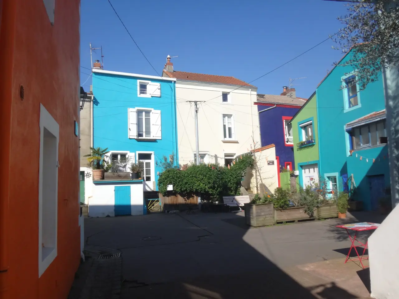 Les maisons aux façades bleues, vertes et violettes d’une placette de Trentemoult, à Rezé