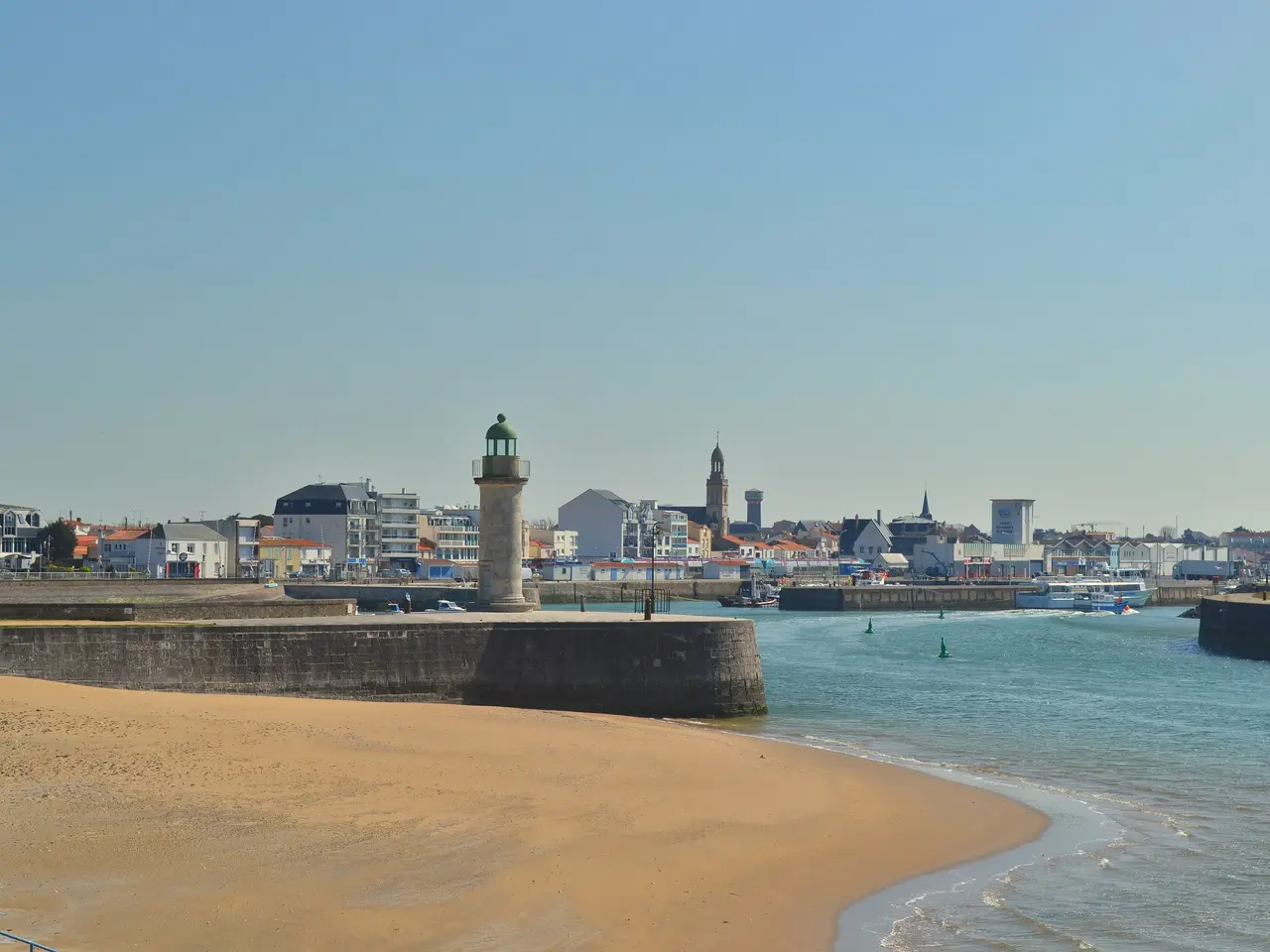 L’entrée du port de Saint-Gilles-Croix-de-Vie, avec la jetée, son phare et une plage de sable