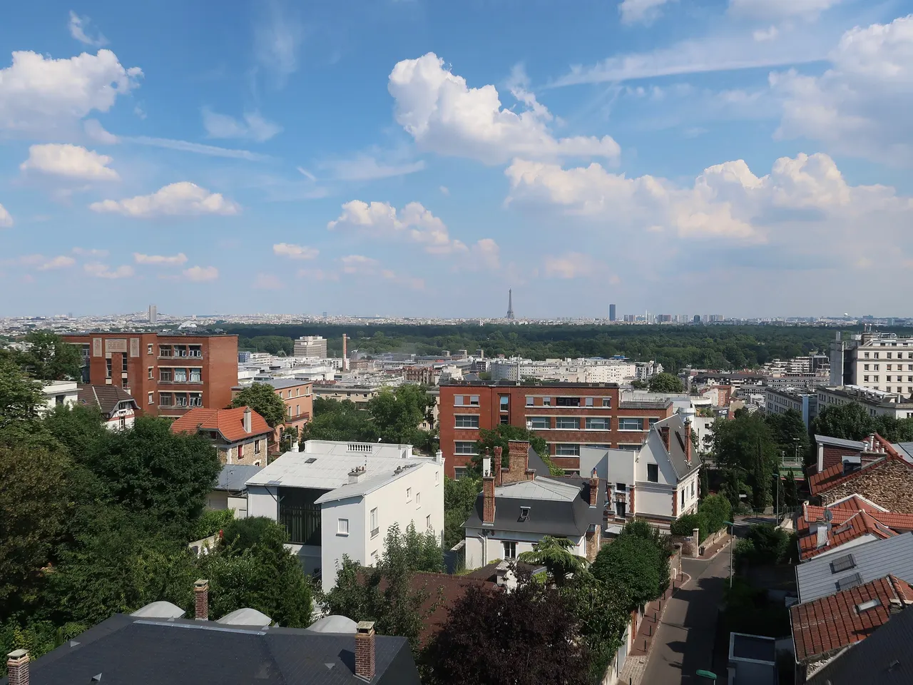 Vue depuis les hauteurs de Suresnes sur les toits de la ville, le bois de Boulogne et Paris jusqu’à la tour Eiffel.