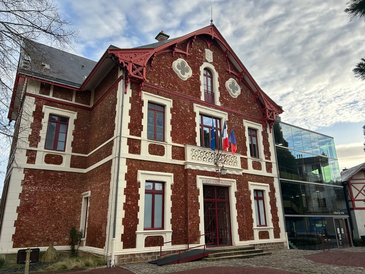 L’hôtel de ville de Viroflay, maison de meulière rouge aux encadrements blancs et à la charpente ouvragée, prolongée d’une aile vitrée